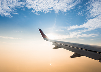 Plane wing with the sun setting behind